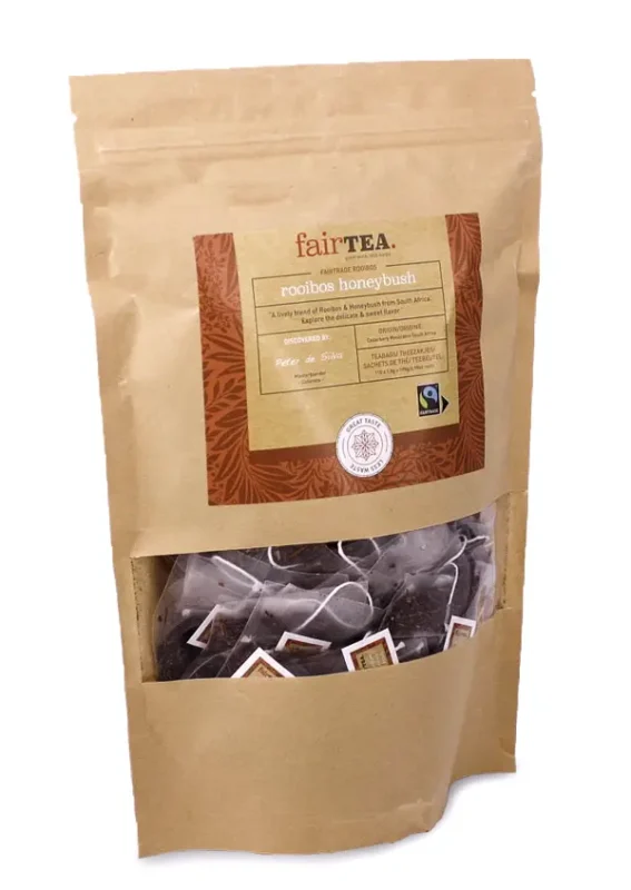 Pakke med FairTea Rooibos Honeybush-te i en brun papirpose med et gjennomsiktig vindu som viser teposer inni.