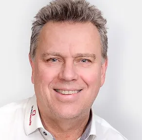 En mann i en hvit skjorte som smiler etter Kontakt Onsite Security-kameraet.